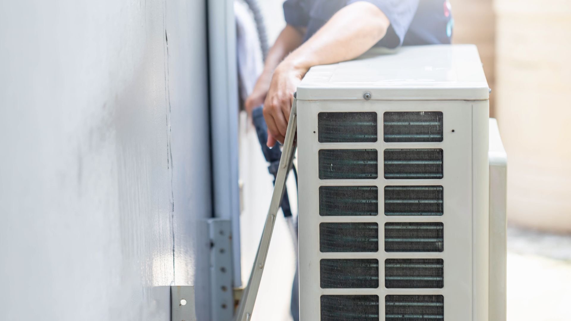 Technician installing or maintaining an outdoor air conditioning unit